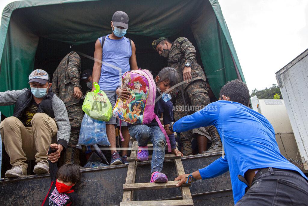Oliver De Ros A Honduran migrant child is helped off a Guatemalan army truck after being returned to El Florido, Guatemala, one of the border points between Guatemala and Honduras, Tuesday, Jan. 19, 2021. A once large caravan of Honduran migrants that pushed its way into Guatemala last week had dissipated by Tuesday in the face of Guatemalan security forces. (AP Photo/Oliver de Ros)