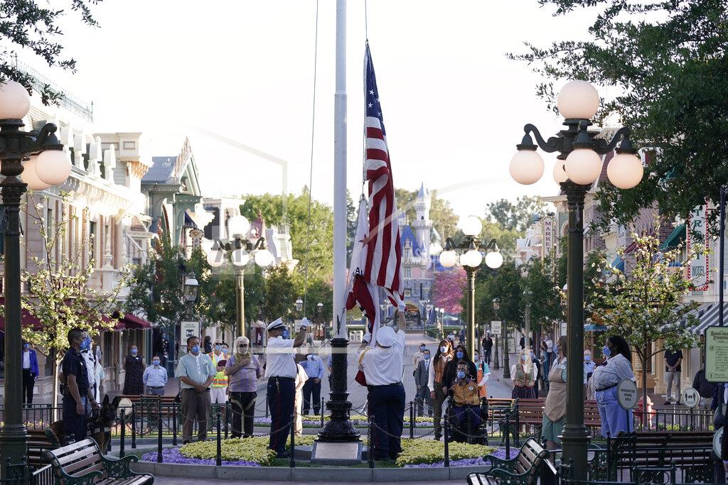 Jae Hong The flag is raised at Disneyland in Anaheim, Calif., Friday, April 30, 2021. The iconic theme park in Southern California that was closed under the state's strict virus rules swung open its gates Friday and some visitors came in cheering and screaming with happiness. (AP Photo/Jae Hong)