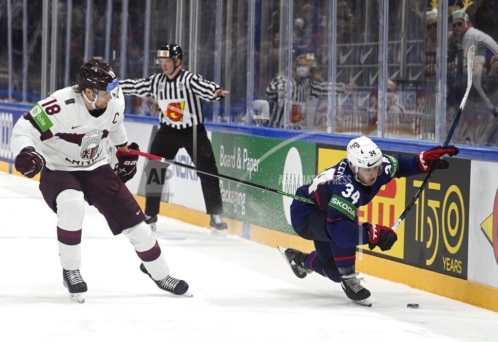 Emmi Korhonen Rodrigo Abols, left, of Latvia, and Thomas Bordeleau of USA vie for the puck during their group B Hockey World Championship match in Tampere, Finland, Friday May 13, 2022. (Emmi Korhonen/Lehtikuva via AP)