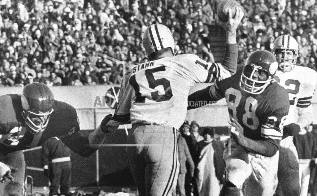 File-This Nov. 23, 1970 file photo shows Green Bay Packers quarterback Bart Starr (15) looking for a receiver as Minnesota Vikings Alan Page (88) charges him and Carl Eller (81), left, grabs his arm during the second half of an NFL game in Minneapolis, Minn. Pro Football Hall of Fame defensive tackle and retired Minnesota state supreme court justice Page has counted art collection among his many life pursuits, and the former Vikings star has two of his prized pieces up for sale through a New York auction house, each valued at more than $200,000. (AP Photo/File)