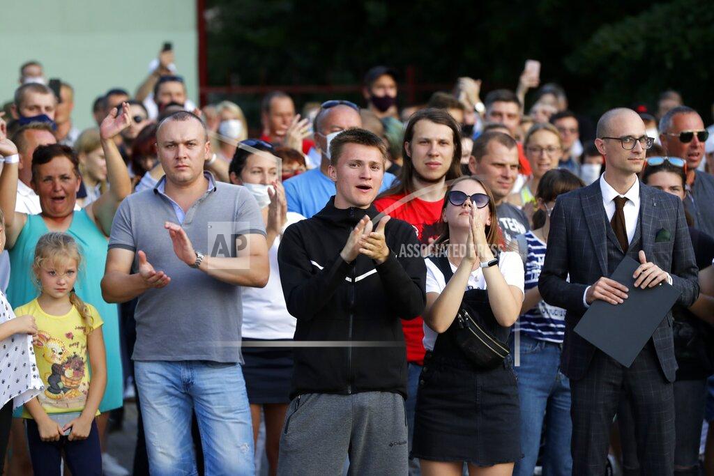 Sergei Grits People applaud police officers as they leave after they attempted to block a rally in support of opposition candidate Sviatlana Tsikhanouskaya ahead of Sunday's election in Soligorsk, Belarus, Tuesday, Aug. 4, 2020. Belarusian police on Tuesday abruptly banned Tsikhanouskaya's previously approved rally in the city of Slutsk, about 100 kilometers (about 60 miles) south of Minsk, under the pretext of road repairs. Officers dispersed several hundred people who had gathered for the rally and detained at least 20 of them, according to Belarusian human rights organization Viasna. (AP Photo/Sergei Grits)
