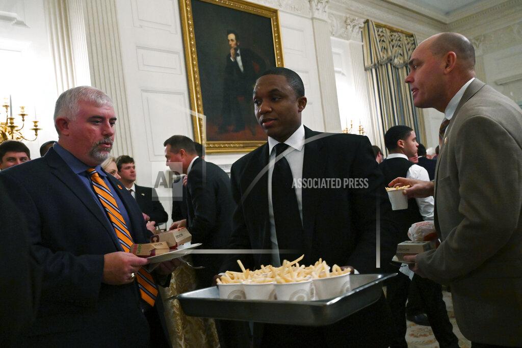 Susan Walsh Guests attending a reception for the Clemson Tigers watch as more French fries are brought out to the State Dining Room of the White House in Washington, Monday, Jan. 14, 2019. (AP Photo/Susan Walsh)