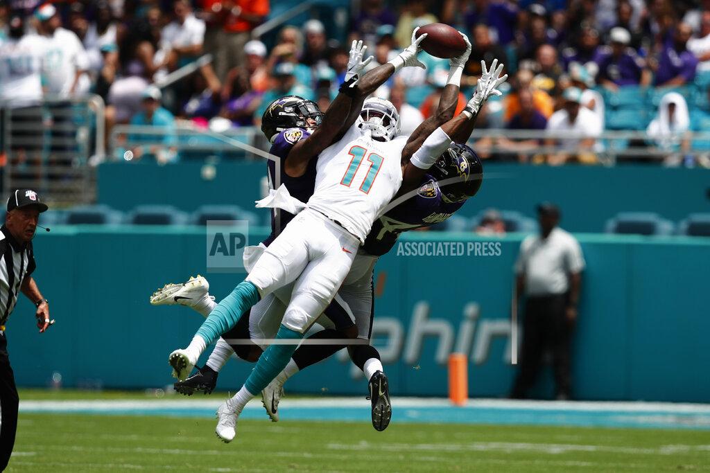 Brynn Anderson Miami Dolphins wide receiver DeVante Parker (11) holds onto a pass as Baltimore Ravens cornerbacks Anthony Averett (34) Marlon Humphrey (44) defend, during the first half at an NFL football game, Sunday, Sept. 8, 2019, in Miami Gardens, Fla. (AP Photo/Brynn Anderson)
