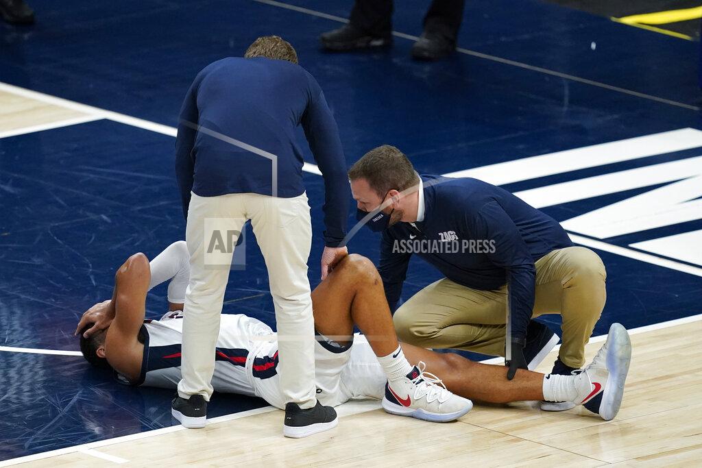 Darron Cummings Gonzaga coach Mark Few stands over Jalen Suggs (1) as he is examined during the first half of the team's NCAA college basketball game against West Virginia, Wednesday, Dec. 2, 2020, in Indianapolis. (AP Photo/Darron Cummings)