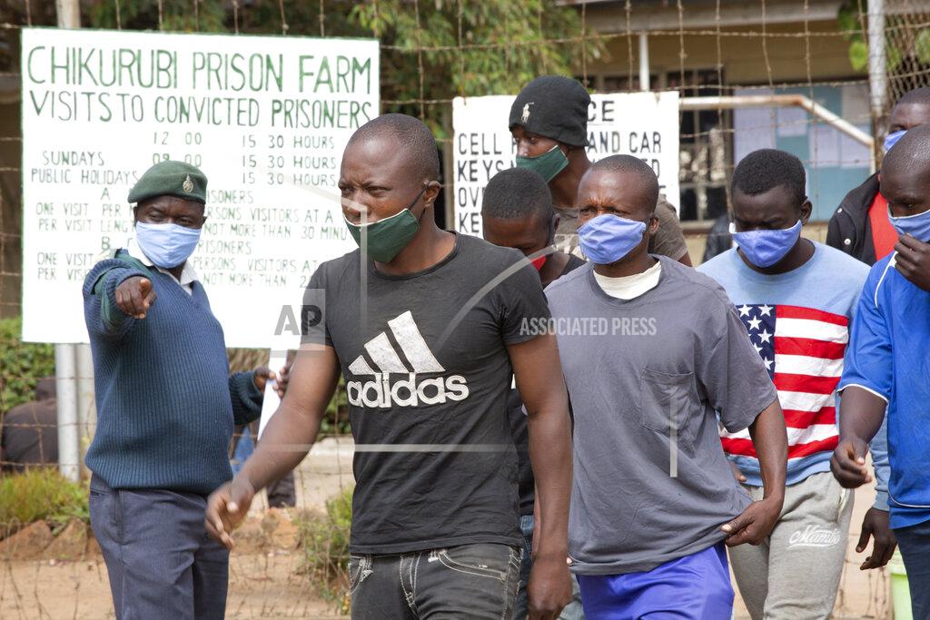 Tsvangirayi Mukwazhi A prison guard directs prisoners following their release from Chikurubi prison on the outskirts of Harare, Saturday, April 17, 2021. Zimbabwe began the release of about 3,000 prisoners under a presidential amnesty aimed at easing congestion and minimizing the threat of COVID-19 across the country's overcrowded jails. (AP Photo/Tsvangirayi Mukwazhi)