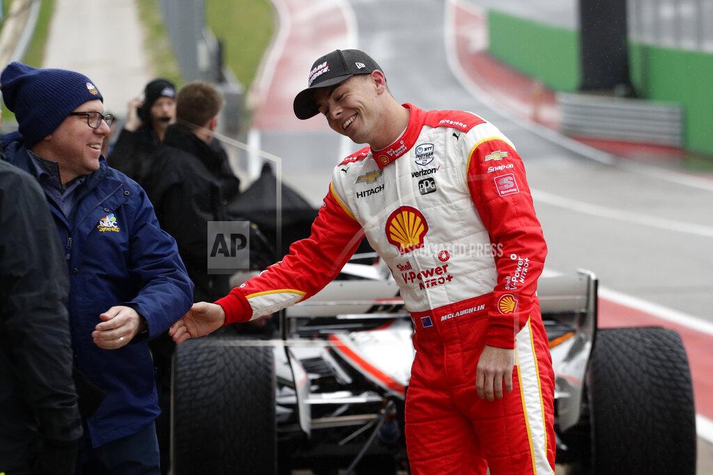 FILE - In this Feb. 11, 2020, file photo, driver Scott McLaughlin, right, jokes with his crew and visitors during IndyCar Series auto racing testing in Austin, Texas. McLaughlin has nothing left to accomplish in Australia after wrapping up his third consecutive Supercars championship last weekend. He boarded a plane immediately after his final race and headed to the United States for his long-awaited IndyCar debut. McLaughlin was supposed to race for Team Penske in May but the pandemic pushed his tryout to Sunday's season finale on the streets of St. Petersburg. (AP Photo/Eric Gay, File)