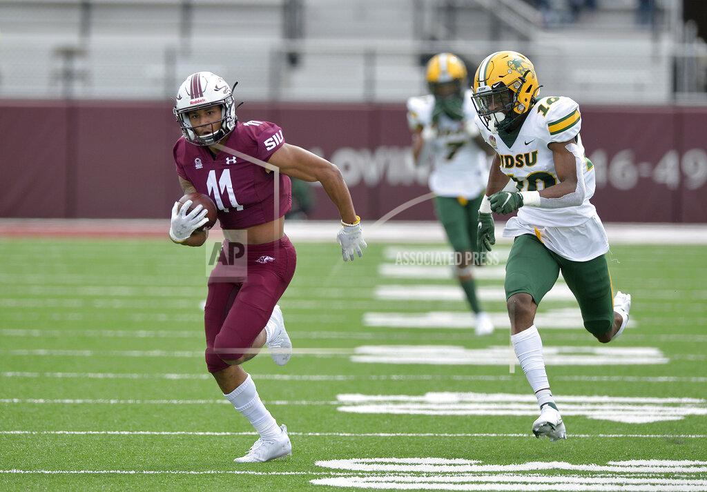 Byron Hetzler Southern Illinois wide receiver Avante Cox (11) sprints away from North Dakota State safety Dom Jones (10) on a 65-yard reception during the second quarter of an NCAA college football game Saturday, Feb. 29, 2021, in Carbondale, Ill. (Byron Hetzler/The Southern Illinoisan via AP)