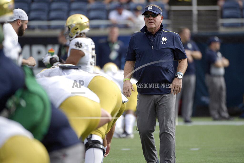 Phelan M. Ebenhack FILE - In this Saturday, Dec. 28, 2019, file photo, Notre Dame head coach Brian Kelly, right, watches warmups before the Camping World Bowl NCAA college football game against Iowa State in Orlando, Fla. Normally, in March, college football teams all over the country would be preparing for the upcoming season. That's gone now, because of the new coronavirus pandemic, and coaches are trying to figure out how to recreate some of what has been lost. (AP Photo/Phelan M. Ebenhack, File)