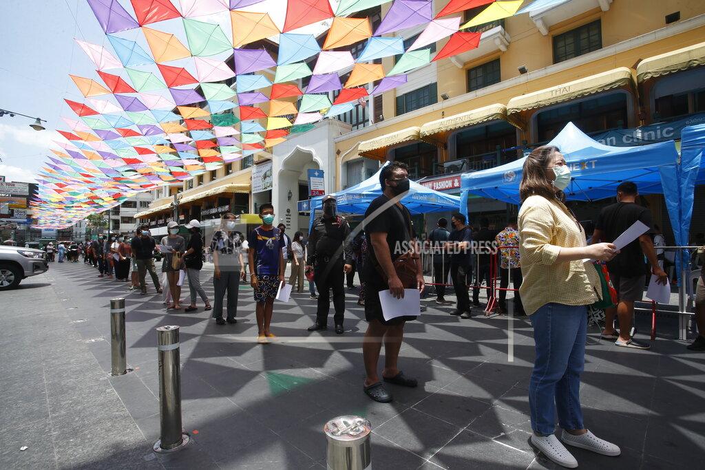 People wait in line for COVID-19 swab tests in Khaosan Road in Bangkok, Thailand Wednesday, April 14, 2021. Thailand recorded more than 1,000 COVID-19 infections on Wednesday, setting a daily record and adding pressure on the government to do more to control the country's spiking transmission rates. (AP Photo/Somchai Chanjirakitti)