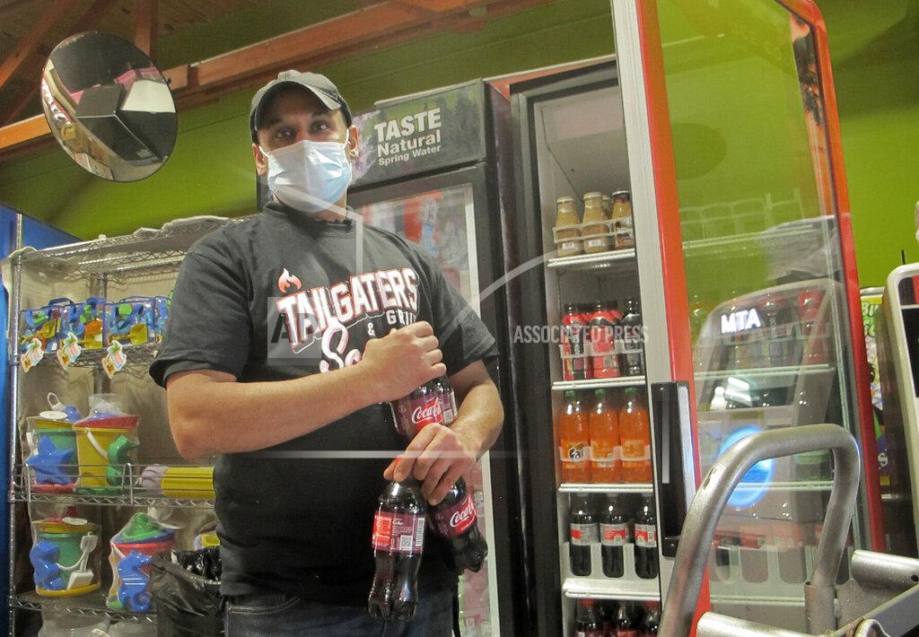 Wayne Parry Raj Kapoor stocks soda bottles at his food court in Belmar N.J. on Tuesday, May 25, 2021. Businesses and residents alike expect this summer at the Jersey Shore to be busier than last year as more people get vaccinated and COVID19 restrictions are scaled back or eliminated. (AP Photo/Wayne Parry)