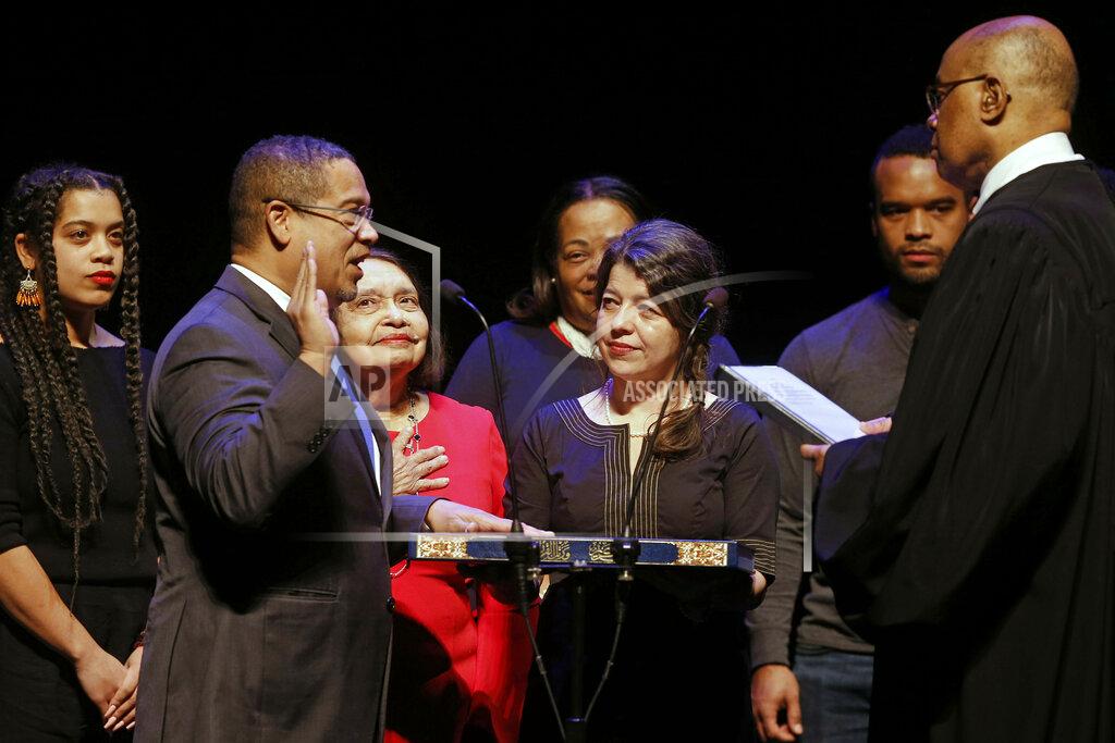 Jim Mone FILE - In this Monday, Jan. 7, 2019, file photo, former U.S. Rep. Keith Ellison, second from left, surrounded by family members, places his hand on the Koran as U.S. District Judge Michael Davis administers the oath of office for the new Minnesota attorney general during ceremonies in St. Paul, Minn. Taking over as lead prosecutor in George Floyd's death is giving Ellison a national platform to talk about race in America. And while Ellison is careful not to talk about details of the criminal cases against four Minneapolis police officers, he's grabbing the opportunity to raise issues about police reform that he's worked on in the past. (AP Photo/Jim Mone, File)