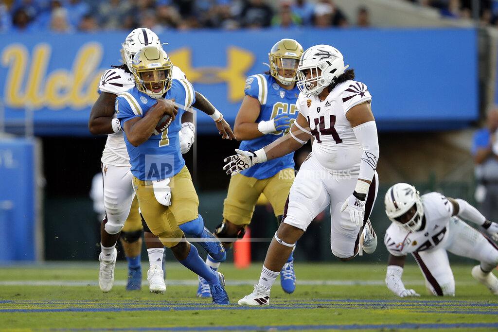 Marcio Jose Sanchez UCLA quarterback Dorian Thompson-Robinson, left, is chased by Arizona State defensive lineman T.J. Pesefea (44) during the first half of an NCAA college football game Saturday, Oct. 26, 2019, in Pasadena, Calif. (AP Photo/Marcio Jose Sanchez)