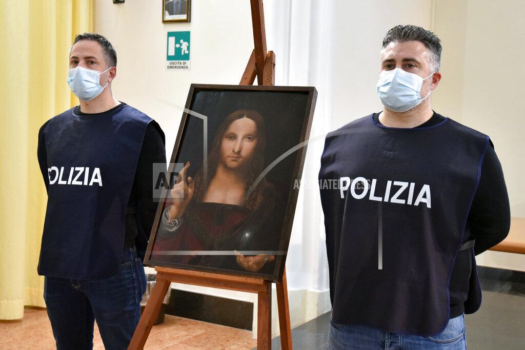 Polizia Di Stato Italian police officers stand by a copy of the “Salvator Mundi” (Savior of the World) by Leonardo da Vinci, in Naples, Italy, Wednesday, Jan. 20, 2021. Italian police have recovered a copy of Leonardo da Vinci’s 16th century “Salvator Mundi” painting of Jesus Christ that was stolen from a Naples church without the priests even realizing it was gone. The discovery was made over the weekend when Naples police working on a bigger operation found the painting hidden in an apartment. Police chief Alfredo Fabbrocini said the owner offered a “less than credible” explanation that he had “casually” bought it at a small market. (Italian Police via AP)