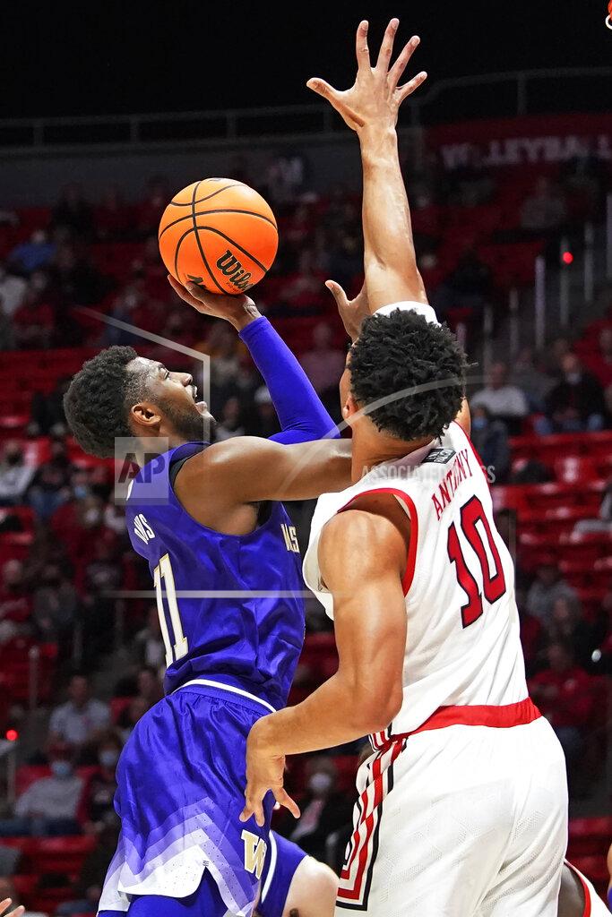 Rick Bowmer Washington guard Daejon Davis (11) shoots as Utah guard Marco Anthony (10) defends during the first half of an NCAA college basketball game Thursday, Jan. 6, 2022, in Salt Lake City. (AP Photo/Rick Bowmer)