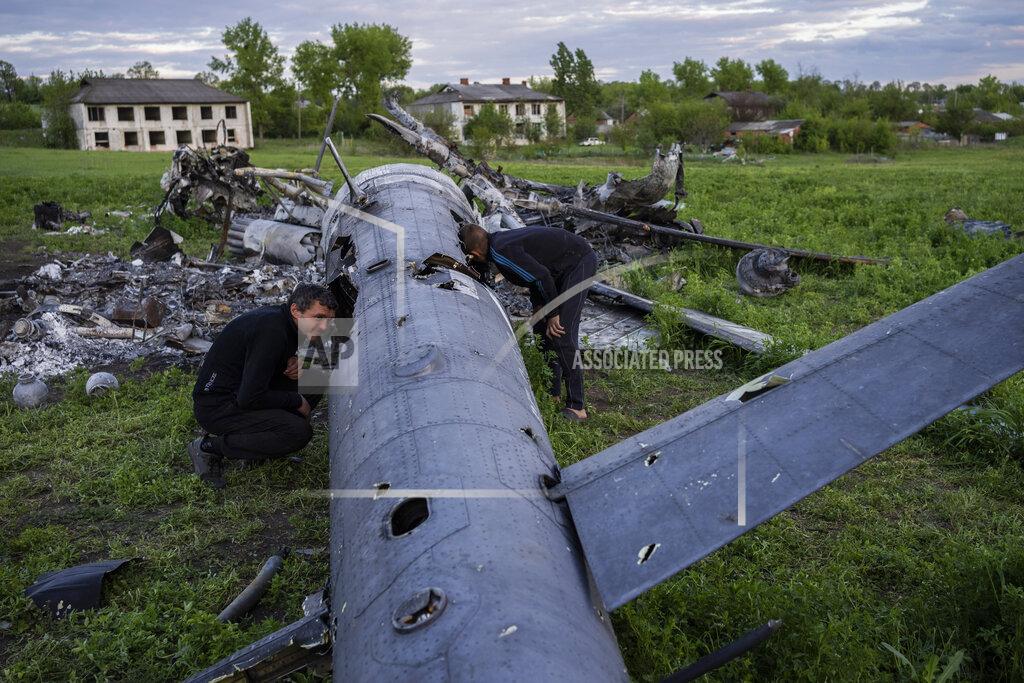 Bernat Armangue Oleksiy Polyakov, right, and Roman Voitko check the remains of a destroyed Russian helicopter lie in a field in the village of Malaya Rohan, Kharkiv region, Ukraine, Monday, May 16, 2022. (AP Photo/Bernat Armangue)