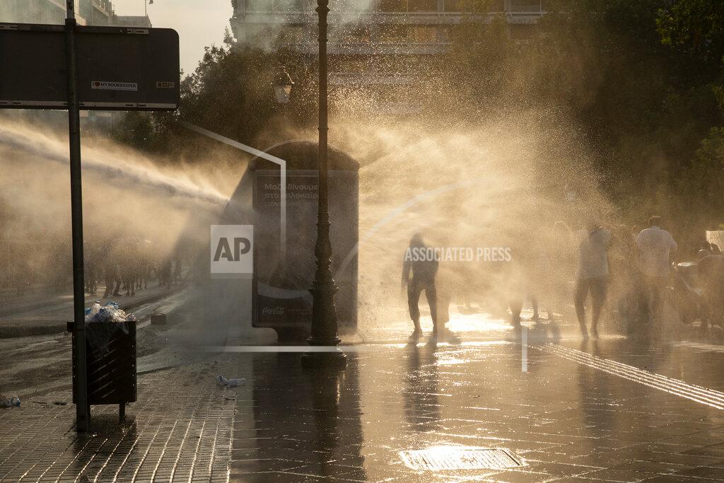 Yorgos Karahalis Greek police use tear gas and water cannons to disperse anti-vaccine protesters during a rally at Syntagma square, central Athens, on Wednesday, July 21, 2021. Thousands of people protested against Greek government's measures to curb rising COVID-19 infections and drive up vaccinations in the country where almost 50% of Greeks and country residents have received at least one dose of the vaccine. (AP Photo/Yorgos Karahalis)