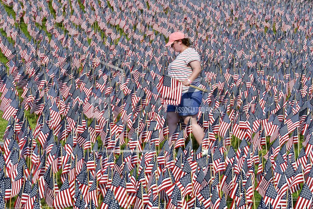Josh Reynolds A volunteer walks through a field of American flags planted on Boston Common ahead of Memorial Day, Wednesday, May 26, 2021, in Boston. After more than a year of isolation, American veterans are embracing plans for a more traditional Memorial Day. They say wreath-laying ceremonies, barbecues at local vets halls and other familiar events are a welcome chance to reconnect with fellow service members and renew solemn traditions honoring the nation’s war dead. (AP Photo/Josh Reynolds)