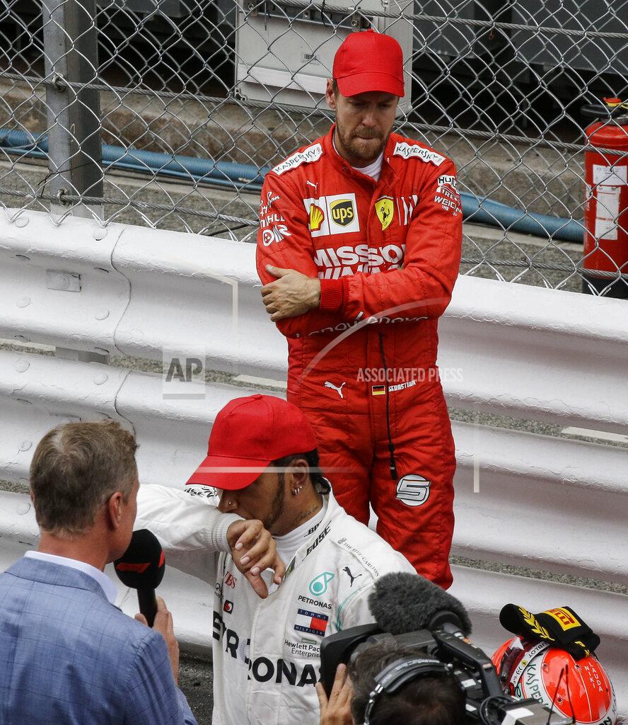 Luca Bruno Second placed Ferrari driver Sebastian Vettel of Germany, up, reacts behind winner Mercedes driver Lewis Hamilton of Britain during the Monaco Formula One Grand Prix race, at the Monaco racetrack, in Monaco, Sunday, May 26, 2019. (AP Photo/Luca Bruno)