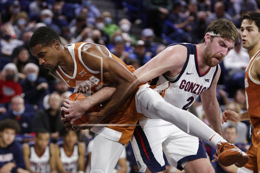 Young Kwak Texas guard Jase Febres, left, grabs a rebound next to Gonzaga forward Drew Timme during the second half of an NCAA college basketball game Saturday, Nov. 13, 2021, in Spokane, Wash. (AP Photo/Young Kwak)