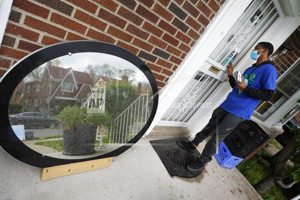 Paul Sancya Sirgregory Allen leaves a flyer at a home in Detroit, Tuesday, May 4, 2021. Officials are walking door-to-door to encourage residents of the majority Black city to get vaccinated against COVID-19 as the city's immunization rate lags well behind the rest of Michigan and the United States. (AP Photo/Paul Sancya)