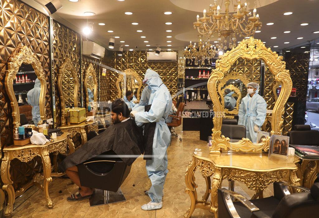Manish Swarup A hairdresser in personal protective suit attends to a customer at a hair salon in New Delhi, India, Friday, June 5, 2020. Businesses and shops reopened in many states as a three-phase plan to lift the nationwide coronavirus lockdown began despite an upward trend in new infections. Indian Prime Minister Narendra Modi’s government has stressed that restrictions are being eased to focus on promoting economic activity, which has been severely hit by the lockdown. (AP Photo/Manish Swarup)