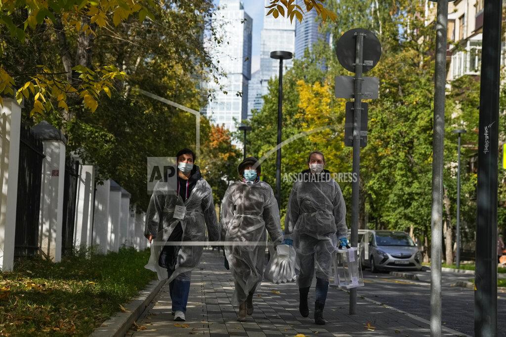 Pavel Golovkin Members of an election commission walk in a street to visit voters who wanted to vote at home during a parliamentary elections in Moscow, Russia, Saturday, Sept. 18, 2021. Sunday, Sept.19 will be the last of three days voting for a new parliament, but there seems to be no expectation that United Russia, the party devoted to President Vladimir Putin, will lose its dominance in the State Duma. (AP Photo/Pavel Golovkin)