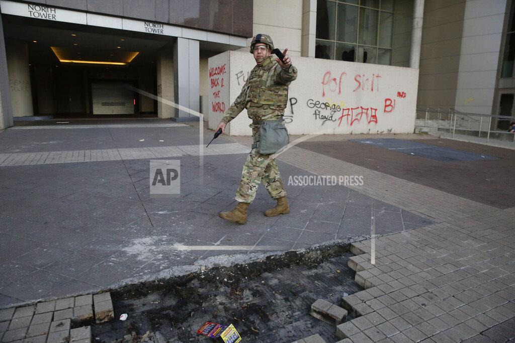 Brynn Anderson A member of National Guard tell bystanders to leave the side of street where damaged has occurred in the aftermath of a demonstration against police violence on Saturday, May 30, 2020, in Atlanta. (AP Photo/Brynn Anderson)