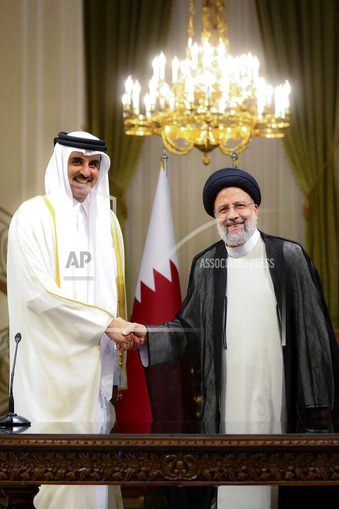 Uncredited In this photo released by the official website of the office of the Iranian Presidency, President Ebrahim Raisi, right, and Qatari Emir Sheikh Tamim bin Hamad Al Thani shake hands for media during their joint press briefing at the Saadabad Palace in Tehran, Iran, Thursday, May 12, 2022. Qatar's emir arrived in Tehran for talks with the Iranian president as efforts to save Tehran's tattered nuclear deal with world powers hit a deadlock. (Iranian Presidency Office via AP)