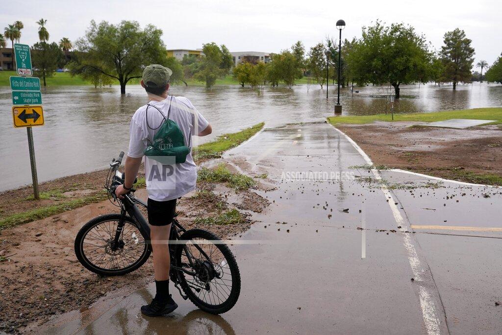 Ross D. Franklin A cyclist is unable to continue his ride as heavy rains caused flooding at Vista del Camino Park, Friday, July 23, 2021, in Scottsdale, Ariz. (AP Photo/Ross D. Franklin)