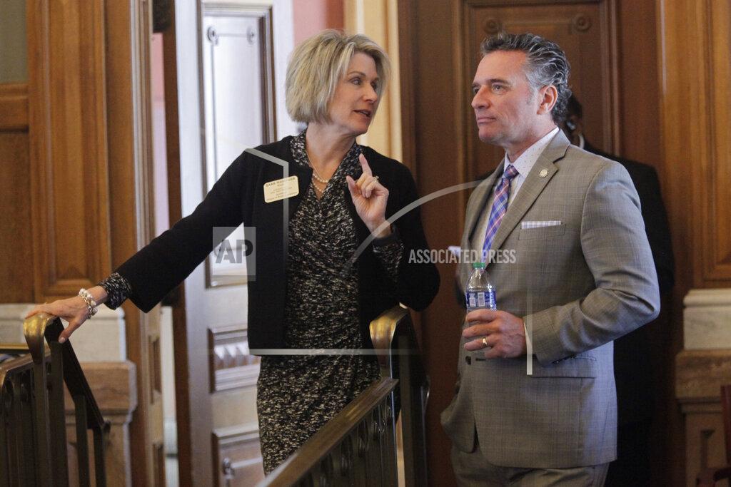 John Hanna Kansas state Rep. Barbara Wasinger, R-Hays, left, confers with Senate President Ty Masterson, R-Andover, right, at the back of the House chamber, Monday, May 23, 2022, at the Statehouse in Topeka, Kan. Lawmakers have approved a bill setting up a program to provide $50 million in relief to businesses that were forced to close or restrict their operations early during the coronavirus pandemic. (AP Photo/John Hanna)