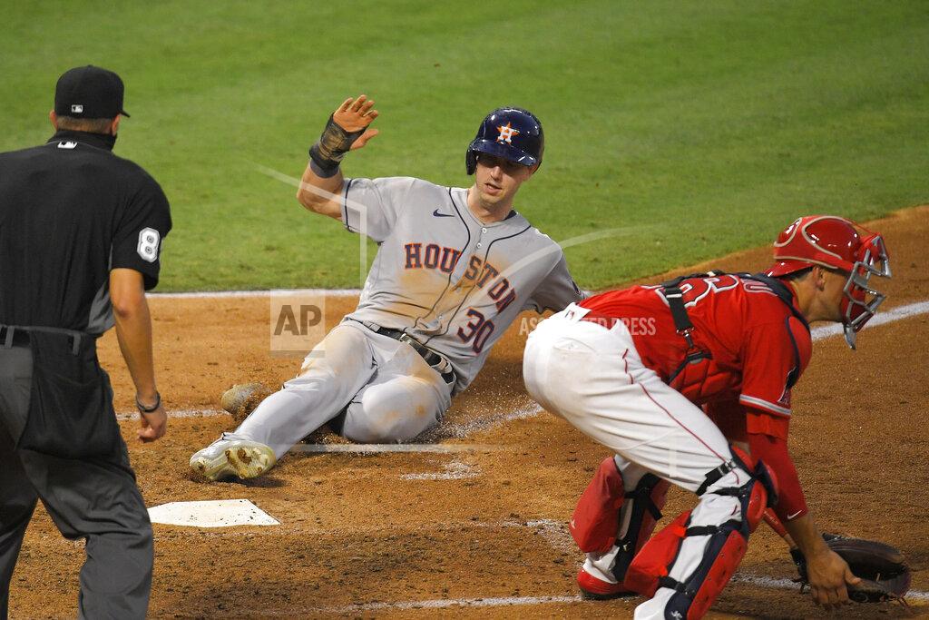 Mark J. Terrill Houston Astros' Kyle Tucker, center, scores on a sacrifice fly by George Springer as Los Angeles Angels catcher Jason Castro, right, takes a late throw and home plate umpire Cory Blaser watches during the fourth inning of a baseball game Friday, July 31, 2020, in Anaheim, Calif. (AP Photo/Mark J. Terrill)