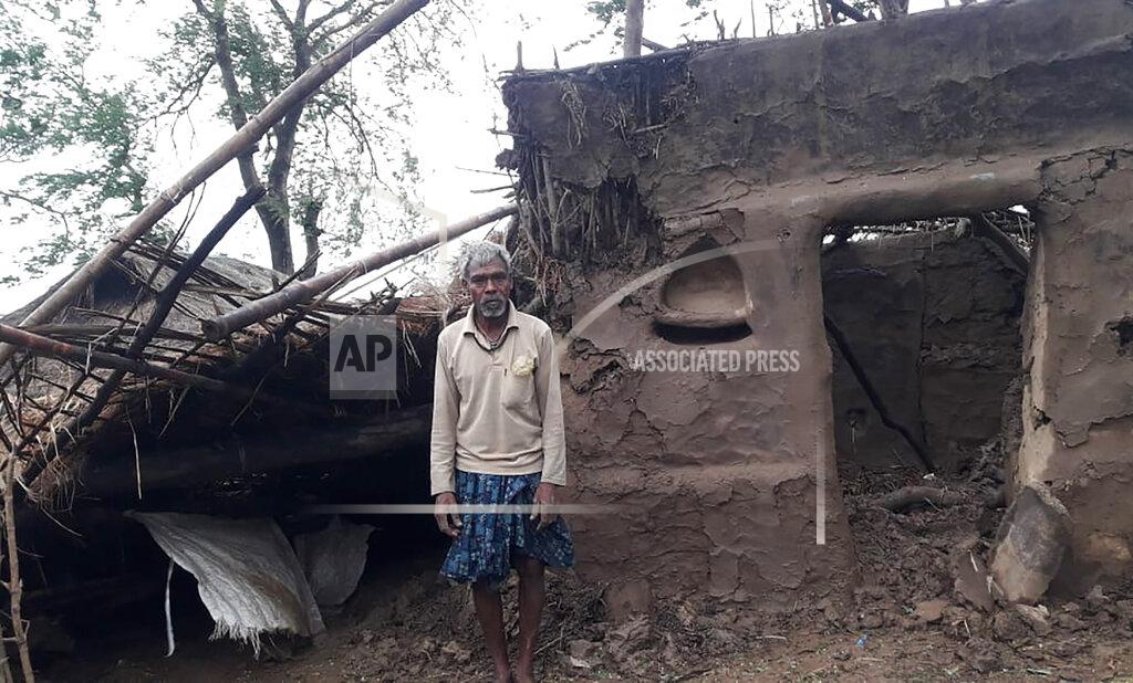 Uncredited This photo provided by the Indian Red Cross Society shows a villager standing outside his damaged house after Cyclone Amphan, the equivalent of a category 3 hurricane, hit the area in Bhadrak district of Orissa state, India, Thursday, May 21, 2020. A powerful cyclone ripped through densely populated coastal India and Bangladesh, blowing off roofs and whipping up waves that swallowed embankments and bridges and left entire villages without access to fresh water, electricity and communications. At least 24 people were reported killed Thursday. (Indian Red Cross Society via AP)