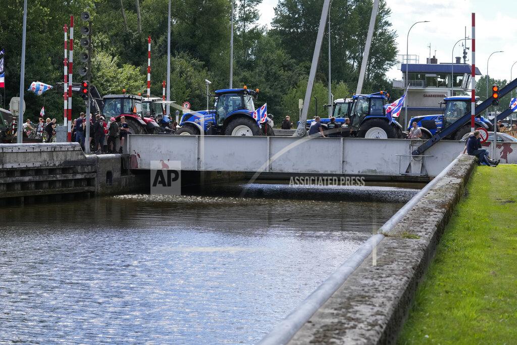 Peter Dejong Protesting farmers block a draw bridge at a lock in the Princess Margriet canal, preventing all ship traffic from passing in Gaarkeuken, northern Netherlands, Monday, July 4, 2022. Dutch farmers angry at government plans to slash emissions also used tractors and trucks Monday to blockade supermarket distribution centers, the latest actions in a summer of discontent in the country's lucrative agricultural sector. (AP Photo/Peter Dejong)