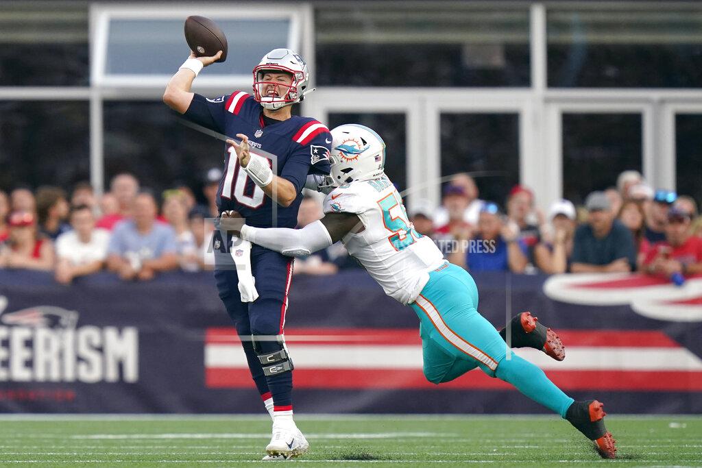 Steven Senne New England Patriots quarterback Mac Jones (10) unloads a pass while pressured by Miami Dolphins outside linebacker Jerome Baker (55) during the second half of an NFL football game, Sunday, Sept. 12, 2021, in Foxborough, Mass. (AP Photo/Steven Senne)