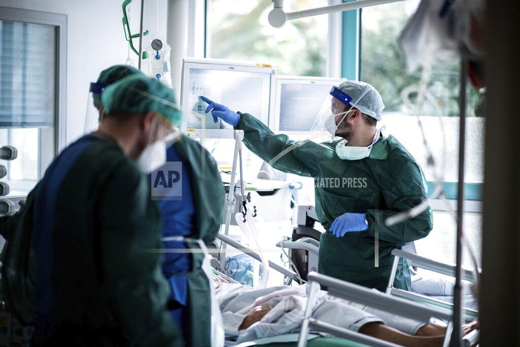 Fabian Strauch Nursing staff in protective equipment cares for a corona patient in a hospital in Essen, Germany, Wednesday, Oct. 28, 2020. People with a new coronavirus infection are treated in the intensive care unit IT2 in the Operative Centre II of the University Hospital Essen. (Fabian Strauch/dpa via AP)