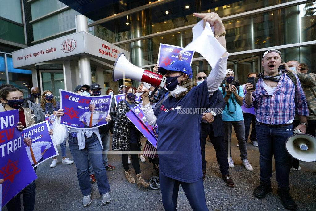 Kathy Willens FILE - In this Oct. 15, 2020, file photo, protesters gather on the sidewalk outside the offices of New York Gov. Andrew Cuomo in New York. After shutdowns swept entire nations during the first surge of the coronavirus earlier this year, some countries and U.S. states are trying more targeted measures as cases rise again around the world. In New York City's borough of Brooklyn, Orthodox Jews have complained their communities are being singled out for criticism. (AP Photo/Kathy Willens)