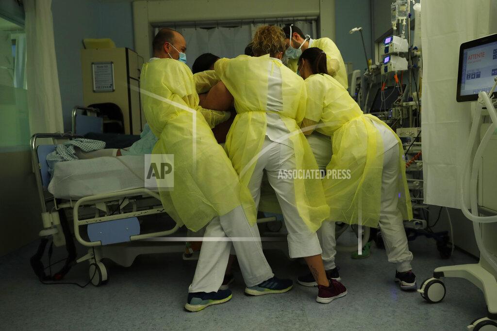Francisco Seco Nurse Anne-Catherine Charlier, right, and co-workers, wearing personal protection equipment, work in the intensive care ward for COVID-19 patients at the CHR Citadelle hospital in Liege, Belgium, Wednesday, Dec. 16, 2020. Belgium has been hit hard by the pandemic with more than 18,000 confirmed deaths. The patient was not confirmed but suspected to have coronavirus. (AP Photo/Francisco Seco)
