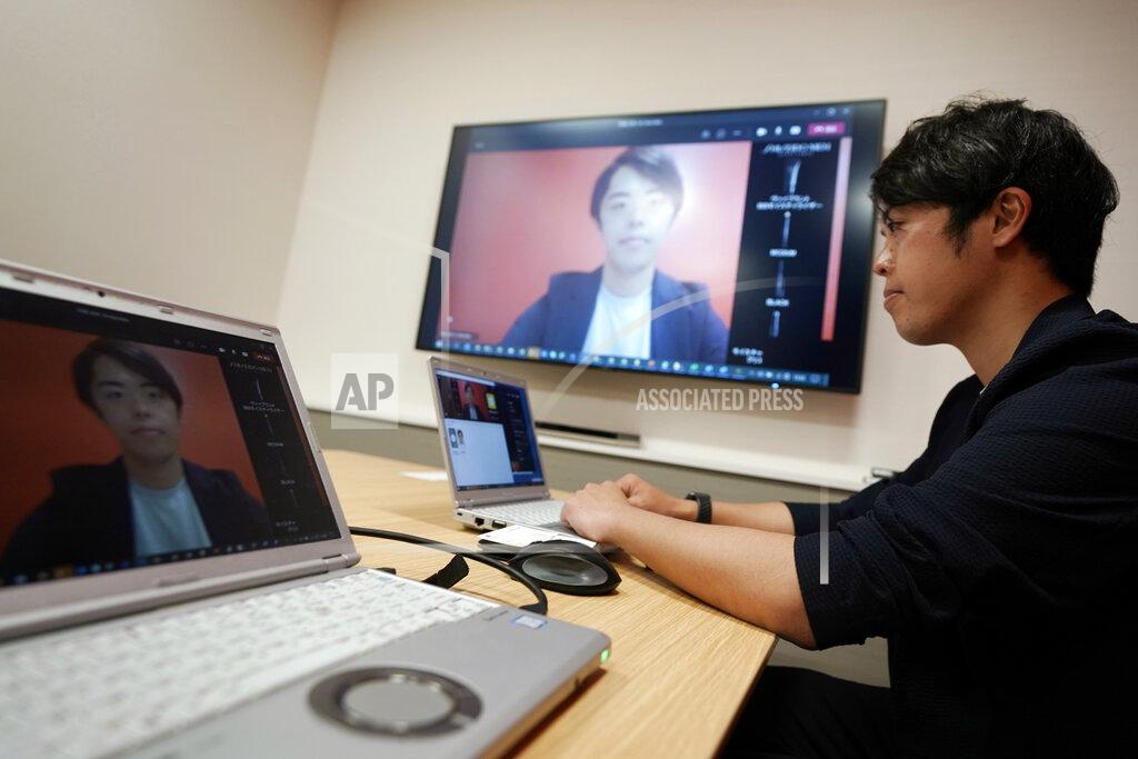 Eugene Hoshiko Naruhiko Ito, assistant brand manager of Brand Shiseido Group, demonstrates Shiseido released AR makeup filter for men to use for online meetings in Tokyo Thursday, April 15, 2021. A large personal care company, Shiseido, says one of its male makeup lines has seen double-digit growth during the coronavirus pandemic. Company officials give a similar reason: Men, confronted with the sight of their faces repeatedly during online meetings, want to improve what they see. (AP Photo/Eugene Hoshiko)