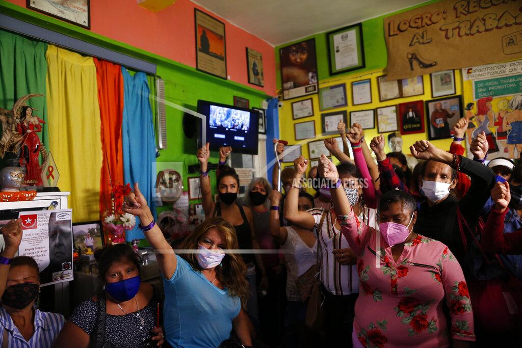Rebecca Blackwell Sex workers raise their fists in solidarity after telling stories about their personal experiences, during a nationwide virtual event to advocate against human trafficking and in favor of rights and recognition for sex workers, ahead of International Women's Day, at the offices the activist group Brigada Callejera or "The Street Brigade", in Mexico City, Saturday, March 6, 2021. (AP Photo/Rebecca Blackwell)