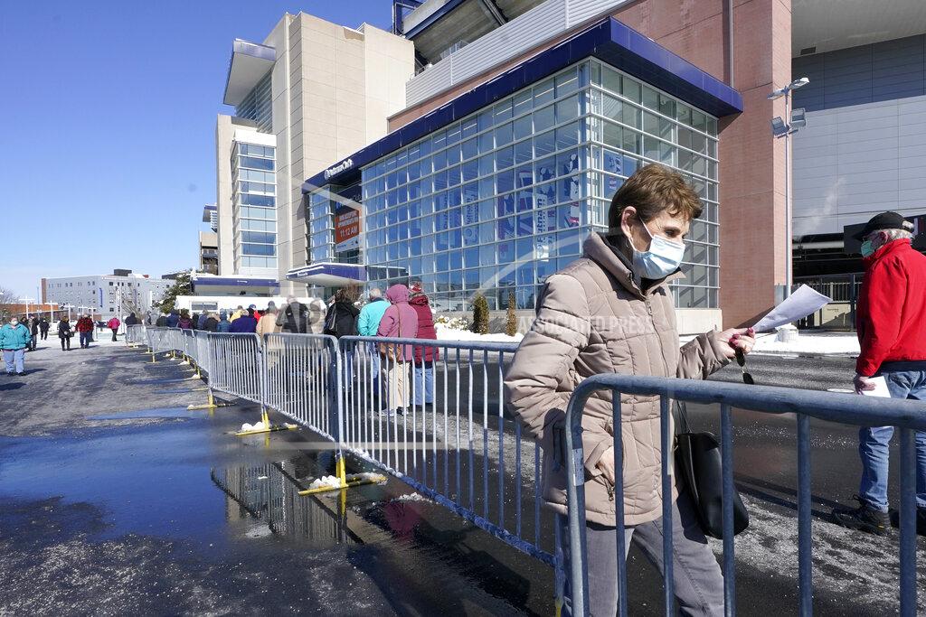 Steven Senne People enter a socially distanced line to get their COVID-19 vaccinations at Gillette Stadium, Monday, Feb. 8, 2021, in Foxborough, Mass. (AP Photo/Steven Senne)