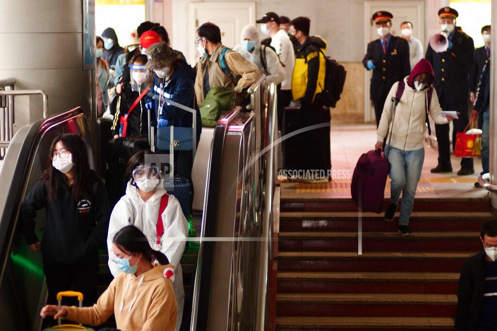 FILE - In this April 15, 2020, file photo, passengers from Wuhan arrive at the train station in Beijing. Getting into Wuhan was the easy part as new infections had fallen to almost zero and travel restrictions were relaxed. As a 76-day lockdown neared its end, journalists were allowed to return to the Chinese city where the coronavirus pandemic originated. But getting out was proving harder. The bureaucracy had yet to finalize how people would safely organize their return and three official documents were needed: A green health code, home neighborhood approval and a recent nucleic acid test. (AP Photo/Sam McNeil, File)