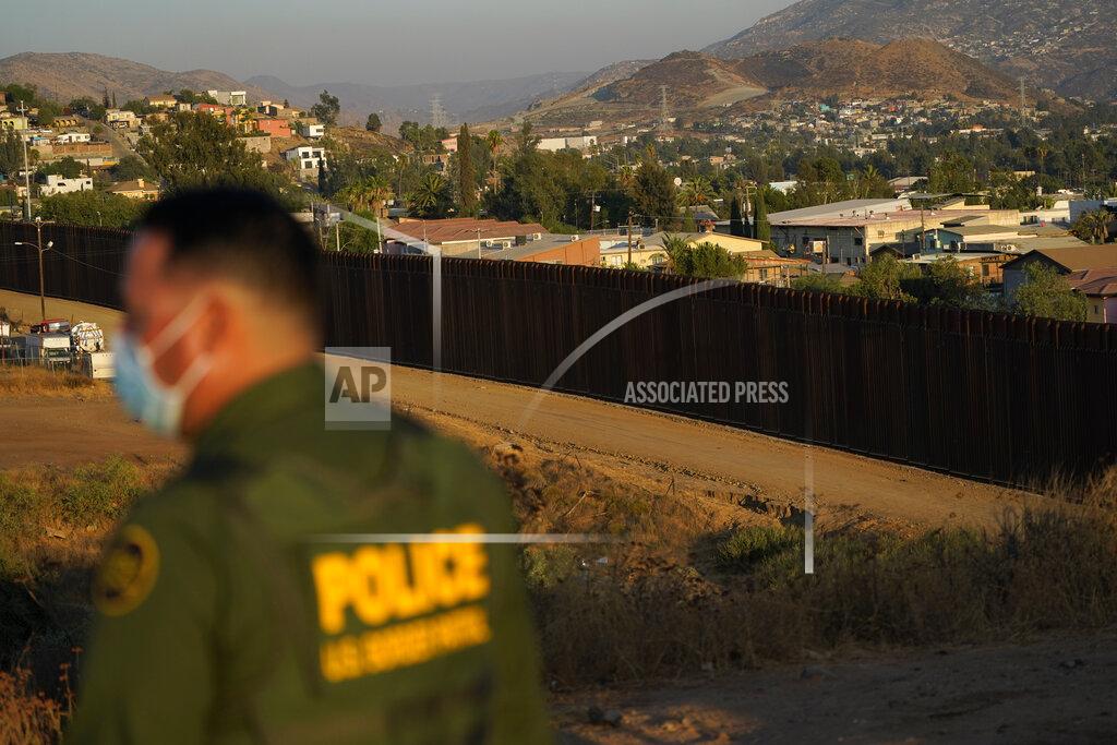 Gregory Bull Border Patrol agent Justin Castrejon looks out along newly replaced border wall sections Thursday, Sept. 24, 2020, near Tecate, Calif. Top Trump administration officials will visit South Texas five days before Election Day to announce they have completed 400 miles of U.S.-Mexico border wall, attempting to show progress on perhaps the president's best-known campaign promise four years ago. But most of the wall went up in areas that already had smaller barriers. (AP Photo/Gregory Bull)