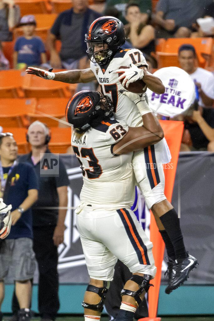 Eugene Tanner Oregon State offensive lineman Gus Lavaka (63) lifts his teammate wide receiver Isaiah Hodgins (17) after Hodgins catches a pass for a touchdown during the first half of an NCAA college football game against Hawaii, Saturday, Sept. 7, 2019, in Honolulu. (AP Photo/Eugene Tanner)