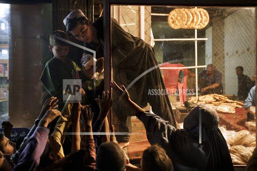Afghan children and women gather outside a bakery to get free bread in Kabul, Afghanistan, Friday, Sept. 24, 2021. (AP Photo/Felipe Dana)