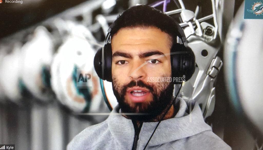 Steve Wine Miami Dolphins NFL football player Kyle Van Roy is shown during a Zoom news conference in this photo made in Miami Lakes, Fla., Thursday, March 26, 2020. The Miami Dolphins practiced safe distancing when they introduced eight newly acquired players hunkered down around the country, holding a series of news conferences via Zoom. The technology changed the dynamics of the conversation, and players seemed to like it. (AP Photo/Steve Wine)