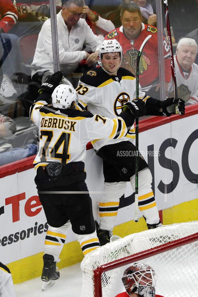 Boston Bruins defenseman Charlie McAvoy, right, celebrates with left wing Jake DeBrusk after scoring against the Chicago Blackhawks during overtime in an NHL hockey game in Chicago, Wednesday, Feb. 5, 2020. The Bruins won 2-1. (AP Photo/Nam Y. Huh)