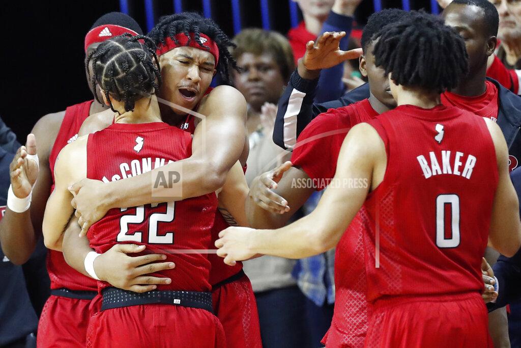 Kathy Willens Rutgers guard Ron Harper Jr.. second from left, embraces guard Caleb McConnell (22) after both players were removed during the second half of an NCAA college basketball upset victory over Seton Hall, Saturday, Dec. 14, 2019, in Piscataway, N.J. Rutgers defeated Seton Hall 68-48. Rutgers guard Geo Baker (0) watches, at right. (AP Photo/Kathy Willens)