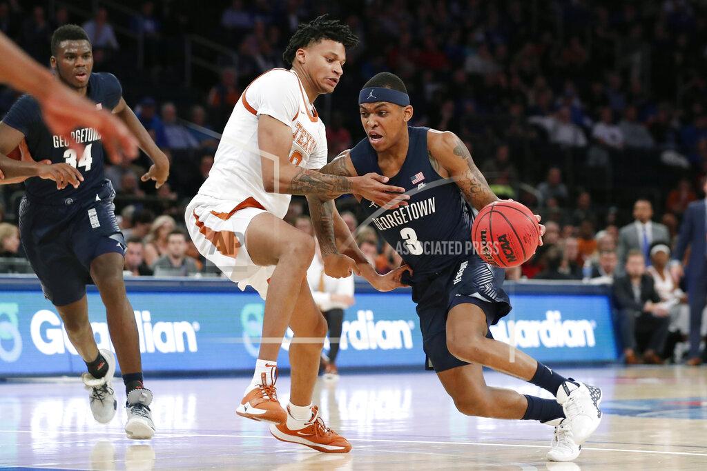 Kathy Willens Texas forward Gerald Liddell (0) defends Georgetown guard James Akinjo (3) who drives to the basket during the second half of the first round of the 2K Empire Classic NCAA college basketball tournament, Thursday, Nov. 21, 2019, in New York. Georgetown defeated Texas 82-66. (AP Photo/Kathy Willens)