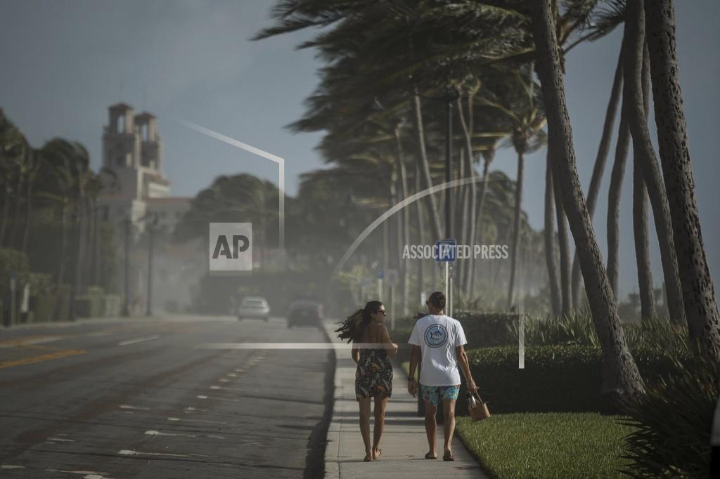 Thomas Cordy Sea spray, sand and winds sweep across South Ocean Boulevard in Palm Beach, Fla., as Palm Beach County readies for Hurricane Isaias on Saturday, Aug. 1, 2020. Isaias snapped trees and knocked out power as it blew through the Bahamas on Saturday and churned toward the Florida coast, where it is threatening to complicate efforts to contain the coronavirus in a hot spot. (Thomas Cordy/The Palm Beach Post via AP)