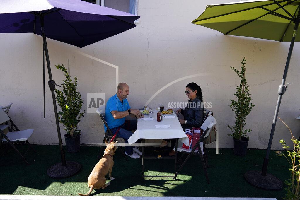 Marcio Jose Sanchez *** Hold For Story *** Steve Flores, left, has lunch with his cousin Carol Salter at Pie 'N Burger Tuesday, Dec. 1, 2020, in Pasadena, Calif. Pasadena has become an island in the center of the nation's most populous county, where a surge of COVID-19 cases last week led to a three-week end to outdoor dining and California's first stay-home order since the pandemic began to spread across the state in March. (AP Photo/Marcio Jose Sanchez)